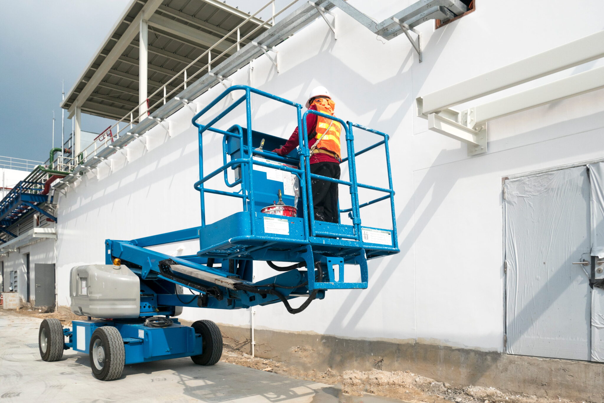 An operator using a manlift outside a building.